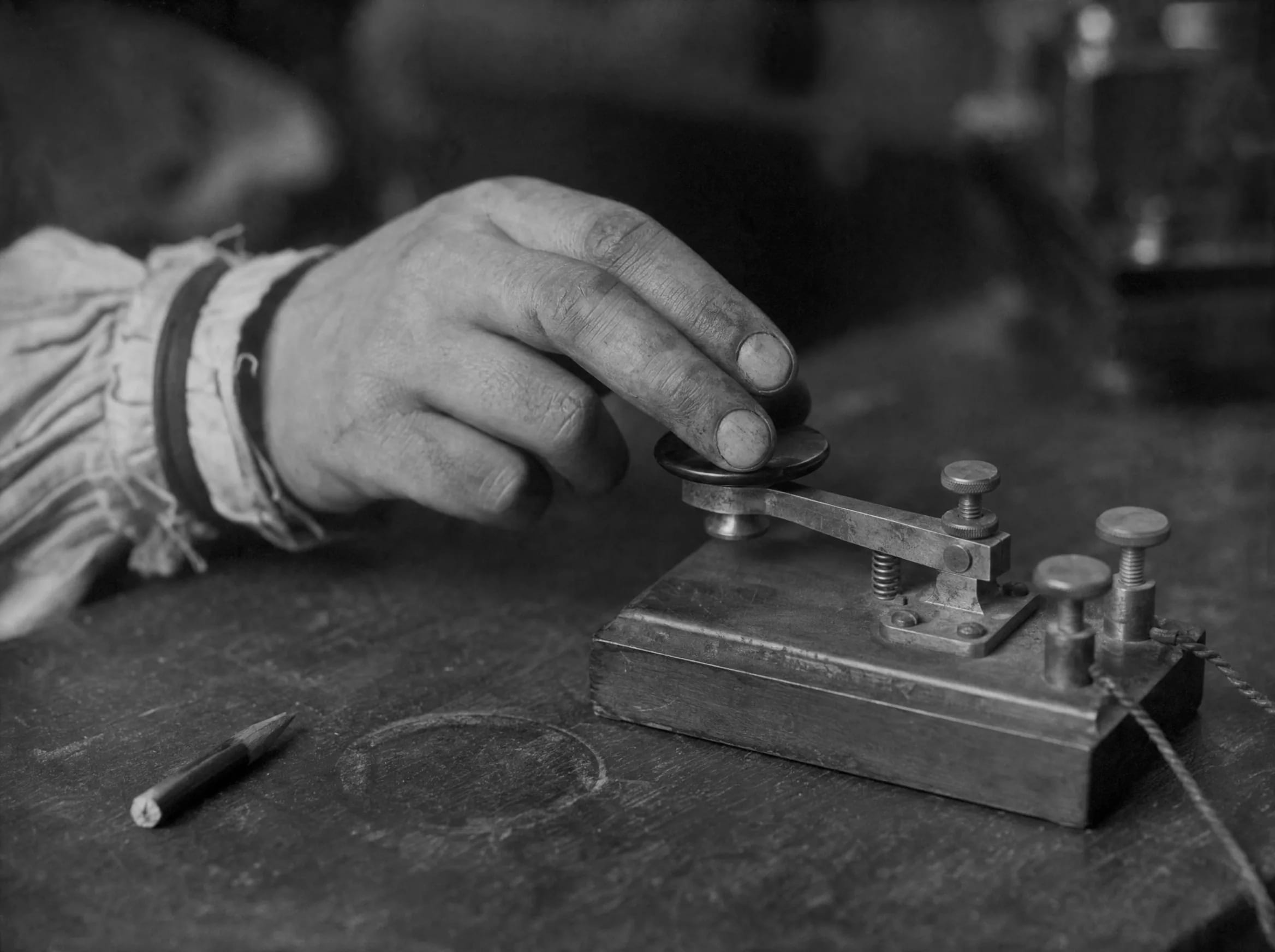 A hand on a brass telegraph key