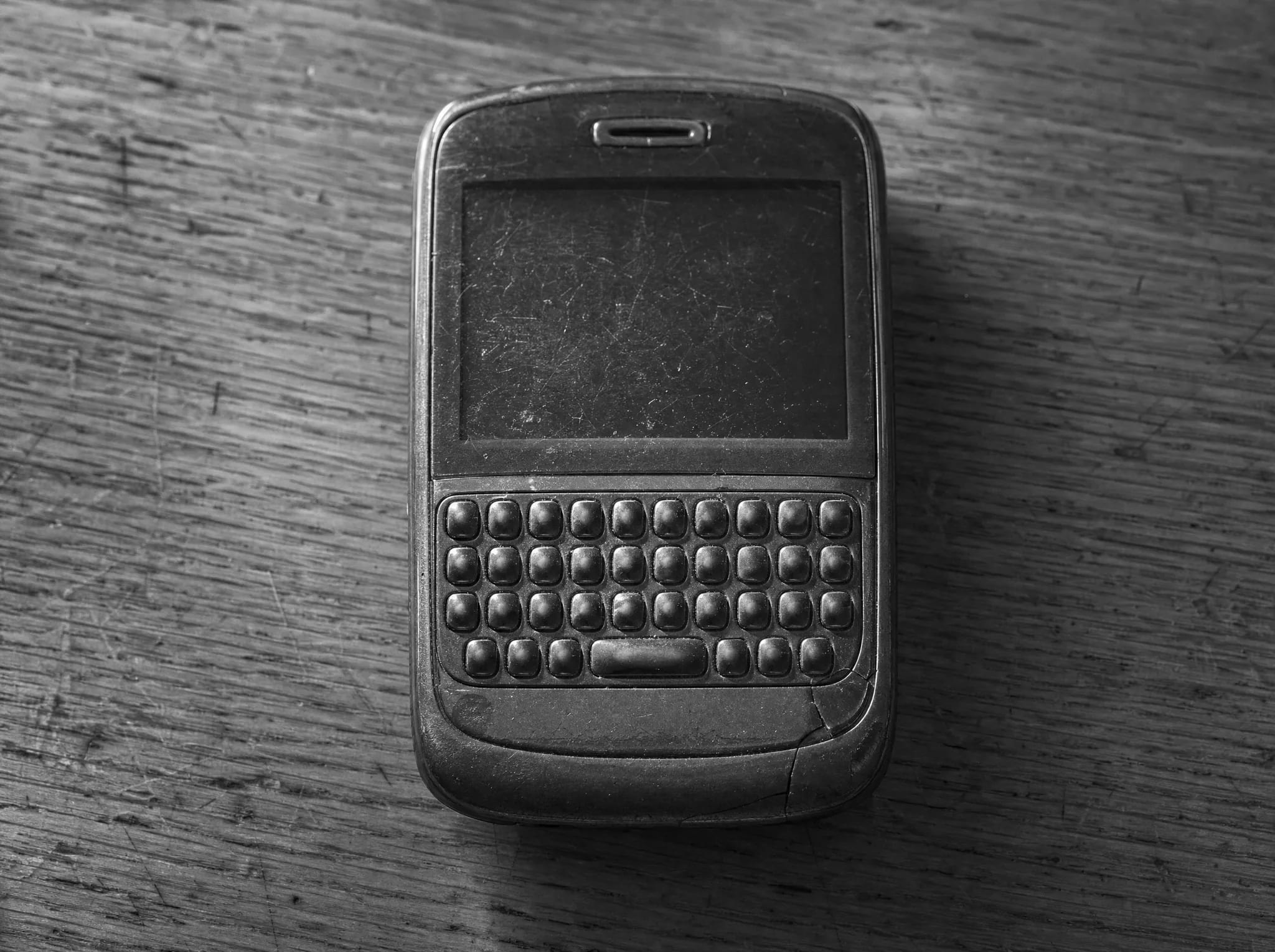 A worn keyboard phone lying on a desk